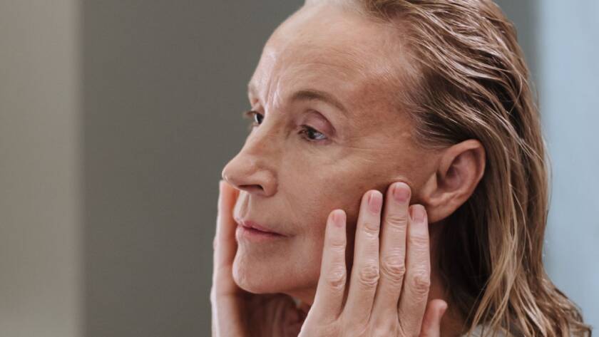 Mulher madura cuidando da pele do rosto, tratamento de envelhecimento na dermatologia integrativa em BH