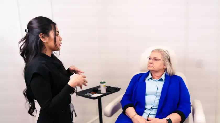 Médica em consulta explicando riscos e cuidados da harmonização facial à paciente