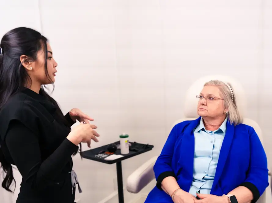 Médica em consulta explicando riscos e cuidados da harmonização facial à paciente