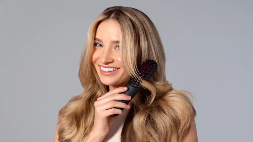 Mulher segurando escova de cabelo com fios, sinal de queda de cabelo feminina